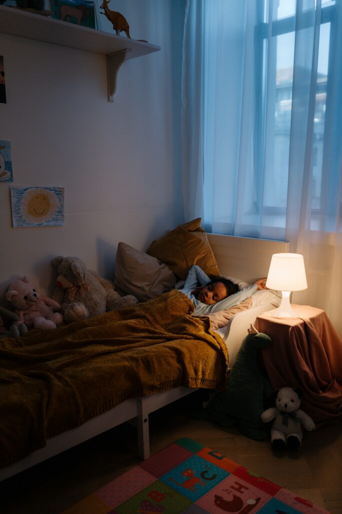 enfant endormi avec une lampe de chevet allumée