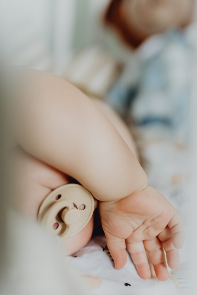 bébé qui dort avec un bras sur ses yeux