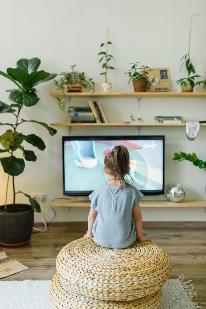 Enfant de la génération de verre assis devant la télévision